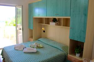 ein kleines Schlafzimmer mit einem Bett mit blauen Schränken in der Unterkunft Villaggio Turistico Defensola in Vieste + 155 Fotos