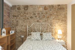 a bedroom with a bed and a stone wall at Lets Holidays apartment Sant Miquel in Tossa de Mar