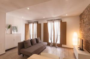 a living room with a couch and two windows at Lets Holidays apartment Sant Miquel in Tossa de Mar