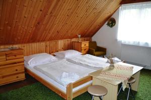 1 dormitorio con 1 cama grande y techo de madera en Penzion Alfa Tatry, en Stará Lesná