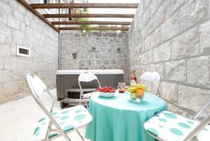 einen Tisch mit einem blauen Tischtuch und zwei Stühlen in der Unterkunft Stone Villa Rea in Mravince
