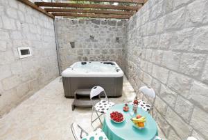 ein Zimmer mit Badewanne und Tisch und Stühlen in der Unterkunft Stone Villa Rea in Mravince + 33 Fotos