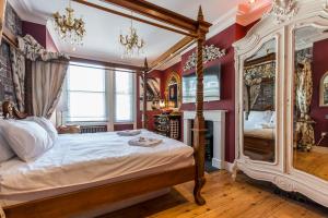1 dormitorio con cama con dosel y paredes rojas en Penthouse, en Londres
