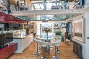 una cocina con una mesa con un jarrón de flores en Penthouse, en Londres