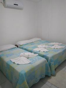 dos camas sentadas una al lado de la otra en una habitación en Pousada Beira Mar, en Recife