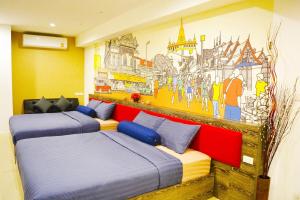 twee bedden in een kamer met een muurschildering. bij Serena Sathorn Suites in Bangkok