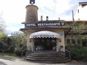 a hotel restaurant with stairs in front of a building at Hotel Castillo in Olaberría