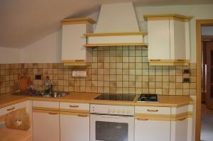 a kitchen with white cabinets and a stove top oven at Ferienwohnung Leachwies in Schenna