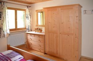 a bedroom with a wooden cabinet and a dresser at Ferienwohnung Leachwies in Schenna