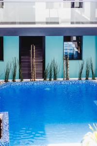 a blue swimming pool in front of a building at Hotel Flamingo Merida in Mérida