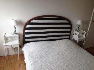 a bedroom with a bed with a black and white headboard at Le cadran in Stella-Plage