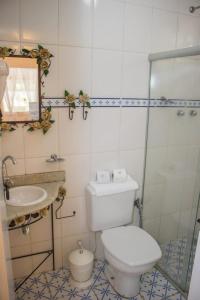 a bathroom with a toilet and a sink at Pousada Hospedaria da Villa in Tiradentes