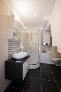 La salle de bains est pourvue d'une douche en verre et d'un lavabo. dans l'établissement Apartment Emili, à Opatija