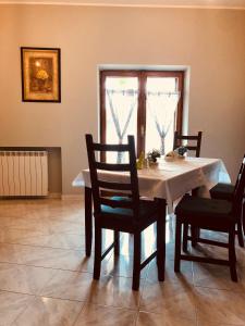 comedor con mesa, sillas y ventana en B&B Viale dei Pini, en Rocca Priora