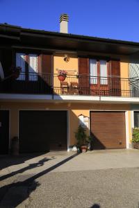 a house with two garage doors and a balcony at B&B La Quiete in Invorio Inferiore