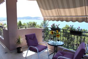 a balcony with purple chairs and a glass table at Vila POGLED in Bar