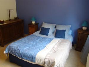 a bedroom with a bed with blue walls and two lamps at Chambres sous les vignes du Buttois in Bussy-le-Grand