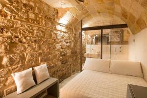 a bedroom with a bed in a brick wall at Dimora Talenti in Polignano a Mare