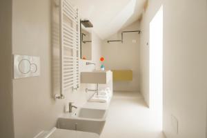 a white bathroom with two sinks and a mirror at Dimora Talenti in Polignano a Mare +37 photos