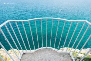 a stairway leading to the ocean with the water at Dimora Talenti in Polignano a Mare