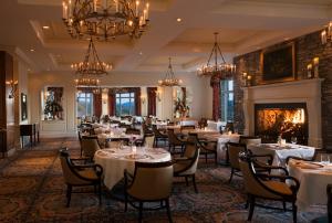 uma sala de jantar com mesas e cadeiras e uma lareira em The Inn On Biltmore Estate em Asheville
