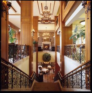 a lobby with a staircase with a chandelier at The Inn On Biltmore Estate in Asheville