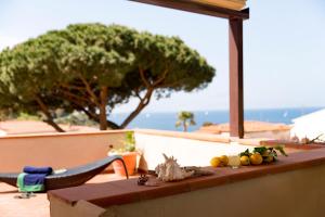 a table with fruit on it with a view of the ocean at Hotel Corallo in Pomonte