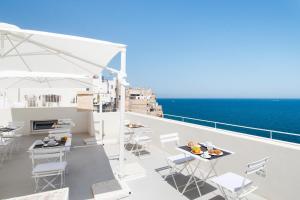 a balcony with tables and chairs and the ocean at Dimora Talenti in Polignano a Mare