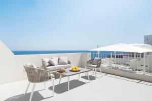 a balcony with chairs and a table on a roof at Dimora Talenti in Polignano a Mare