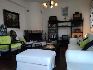 sala de estar con sofá blanco y sillas en Sotiros Sunset House en Skala Sotiros