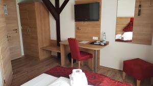 a hotel room with a desk and a bed and a bedroom at Hotel Elb Blick in Jork