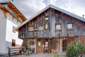 a wooden house with a gambrel roof at Cianbolpin Guesthouse in Canazei