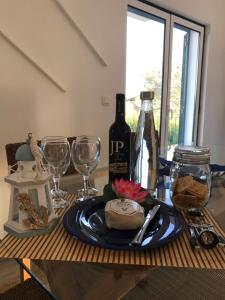 a table with a bottle of wine and wine glasses at Casa do Farol da Arrábida in Portinho da Arrábida