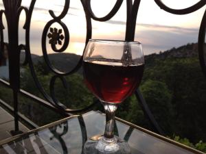 a glass of wine sitting on top of a table at Sotiros Sunset House in Skala Sotiros