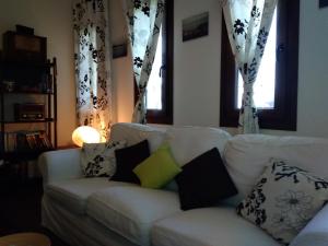 un sofá blanco con almohadas en la sala de estar en Sotiros Sunset House en Skala Sotiros