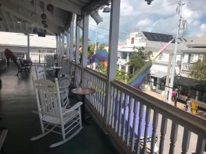 um alpendre com cadeiras, uma mesa e um parque infantil em New Orleans House - Gay Male Adult Guesthouse em Key West