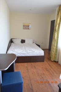 a bed in a room with a desk and a table at Guesthouse Opal in Ravda