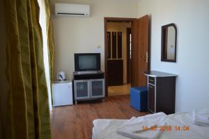a living room with a television and a bed at Guesthouse Opal in Ravda