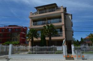a building with a white fence in front of it at Guesthouse Opal in Ravda