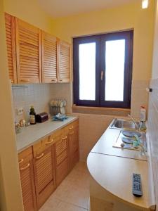 a kitchen with a counter and a sink and a window at Apartments Mladen in Njivice