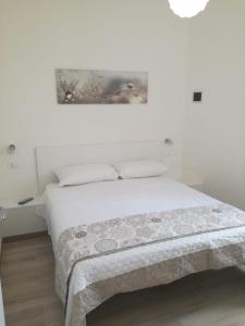 - une chambre blanche avec un lit et une couverture dans l'établissement Cuore Galateo, à Galatone