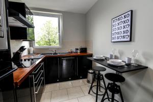 una cocina con encimera negra y taburetes. en Apartment F, en Aberdeen