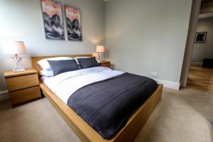 a bedroom with a large bed with blue pillows at Apartment F in Aberdeen