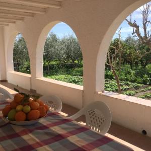 un tavolo con una ciotola di frutta sopra con finestre di El cortijo de la abuela a Benahadux