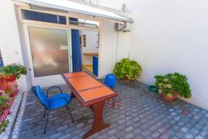 un patio con una mesa y algunas sillas azules en Apartments Paunovic, en Makarska