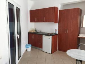 a small kitchen with wooden cabinets and a table at Eugenia travasarou sea view appartments in Diakofti
