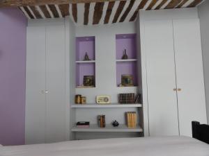 a bedroom with white cabinets and purple walls at La Maison des Augustines in Marseille