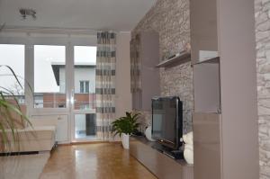 a living room with a tv and a stone wall at BS Business Travelling Hannover Messe in Hannover