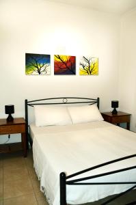 a bedroom with four paintings on the wall at Sky-Line Apartments in Afantou