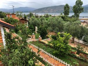 a garden with trees and a white fence at The Mussel House in Ksamil